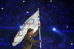 Kate Courtney receives the Olympic flag from Tom Cruise in the transition towards Los Angeles 2028